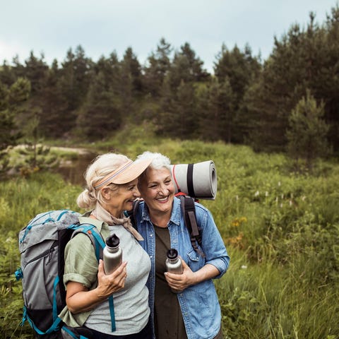 Two older adults in field together on a hike.