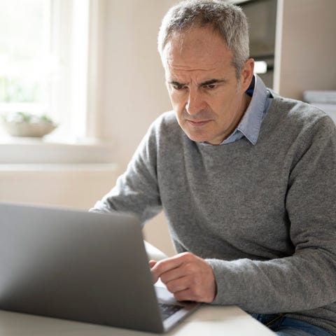 A person with a serious expression at a laptop.