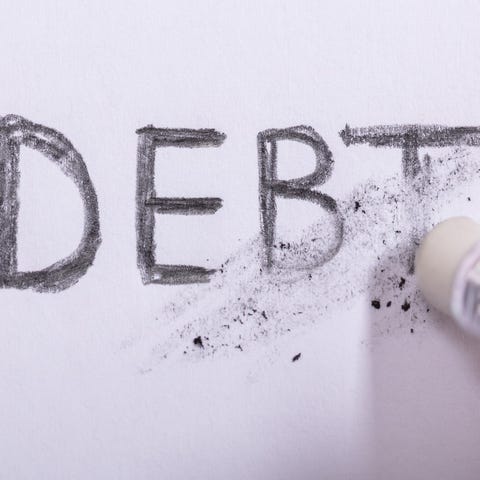 An eraser rubbing out the word debt.