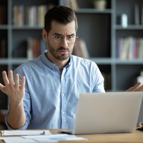 Confused person looking at laptop.