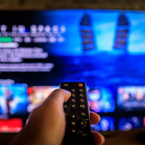 A person pointing a remote at a TV a streaming ser