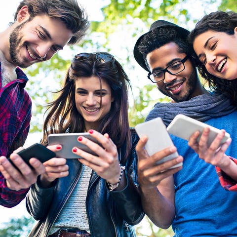 Friends looking at their smartphones.