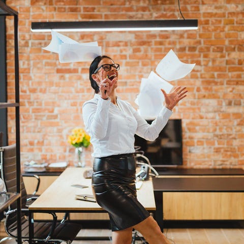 An office worker throws paperwork in the air.