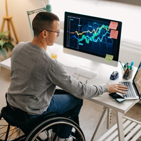 Person in wheelchair looking at stock charts on co