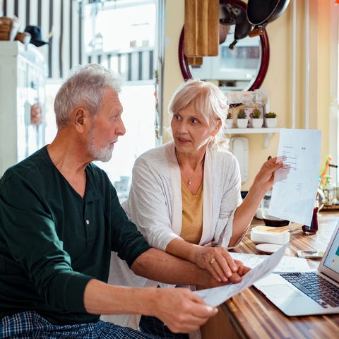 Two people sitting at table looking at computer an