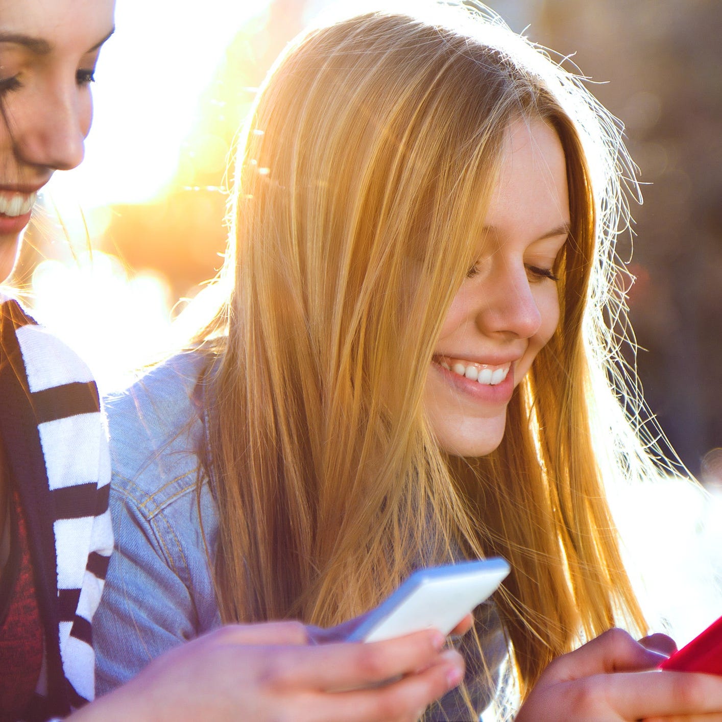 Two people texting on their smartphones.