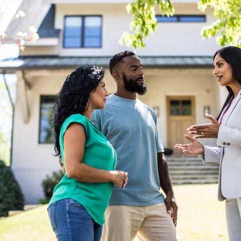 Realtor showing a house to two interested buyers.