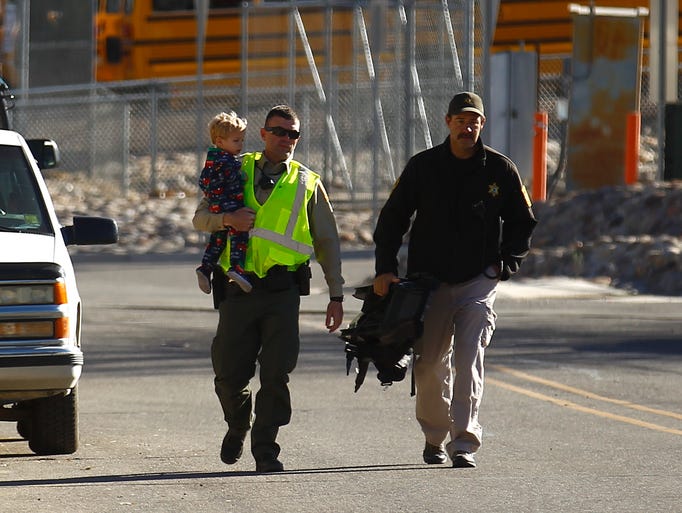 San Juan County sheriff's deputies carry away a child