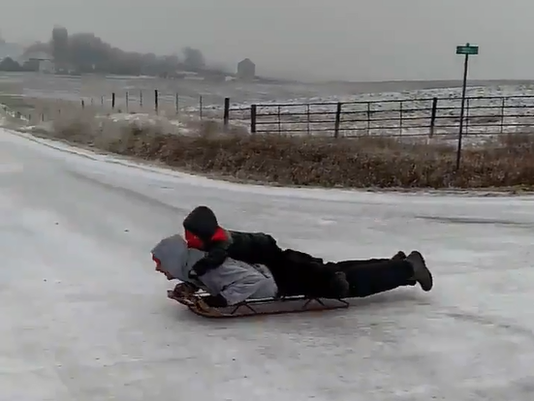 Iowans zip down icy road on sleds as seen in viral video