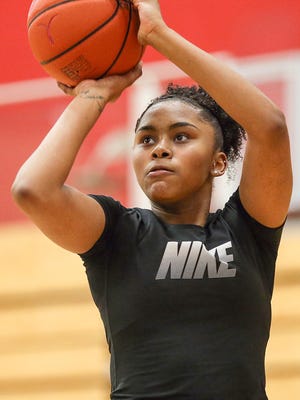 Trinity Brady shoots during a workout with her younger brother Vincent and her cousin Garrett Holland at Lawrence North High School, Sunday evening, Jan. 21, 2018. A car accident in 2016 left Trinity with a traumatic brain injury, causing severe chronic head pain and mental setbacks like post-traumatic stress disorder and depression. In the past year, Trinity has finally found treatment to improve her chronic pain. While she is still working through some mental and physical setbacks, she is once again a leading scorer for Lawrence North.