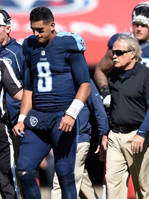 Titans quarterback Marcus Mariota is trailed by team doctor Burton Elrod after injuring a knee against the Dolphins in October at Nissan Stadium. Mariota remained in the game.