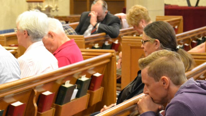 Pastor Bryan Robles of Victory Church, foreground, and other members of the community pray together during Thursday’s National Day of Prayer event.