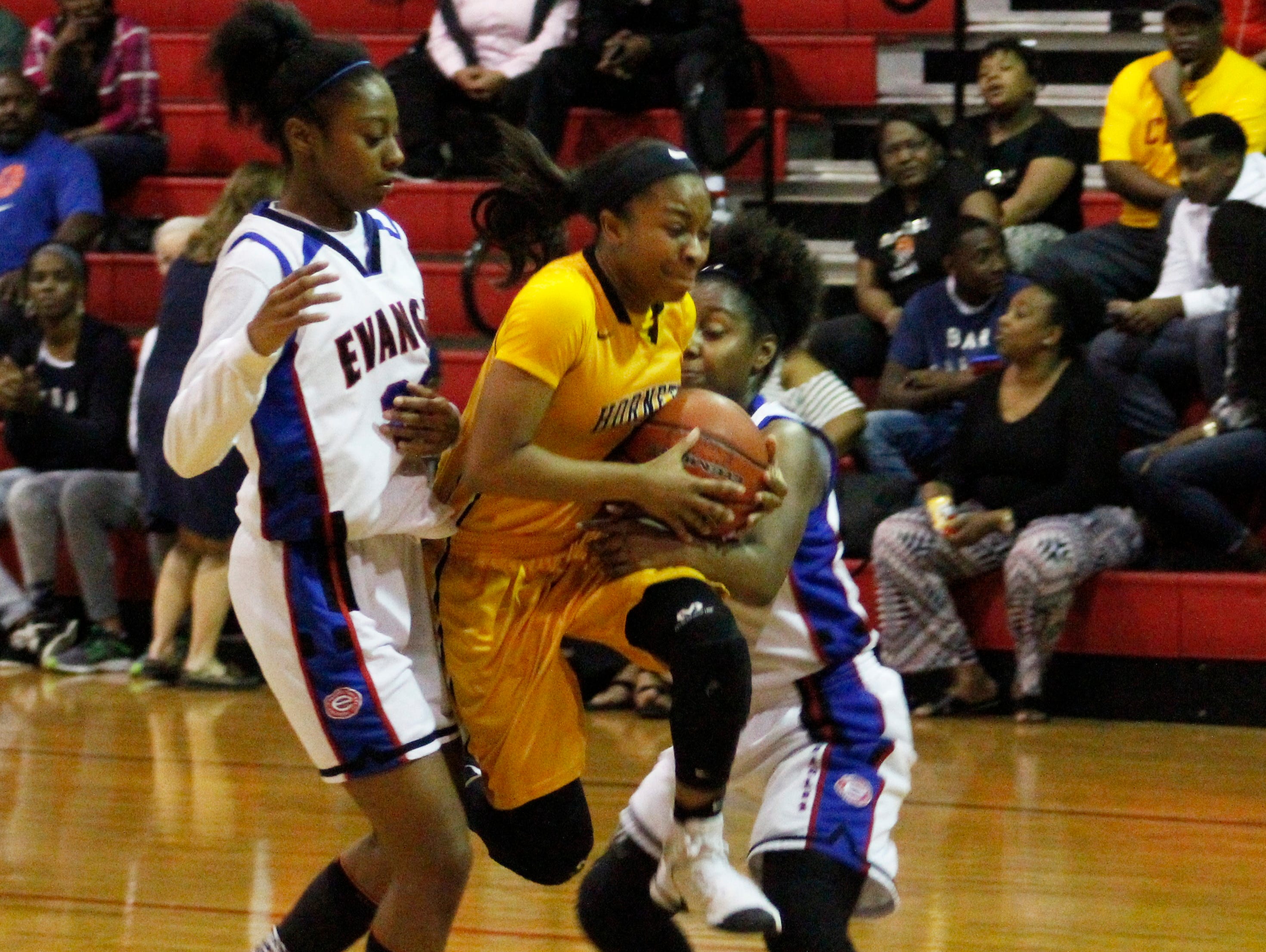 A Scotlandville player forces her way between Evangel's Tiara Young (left) and Madison Laboy. The Lady Hornets won the game.