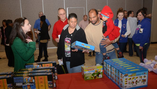 ANI Rotary TT Doll and Toy FundJordan Buchanan (far left, green coat) and Jay Lynch (back, red shirt), both with the Rotary Club of Alexandria, help Sharon Roberts (second from left, black coat) and Harvey McNeal (beige shirt) shop look for a gift for son Ladarius Roberts, 2, at the annual Doll & Toy Distribution sponsored by the Rotary Club of Alexandria and The Town Talk. The event was held Saturday, Dec. 20, 2014 at Alexandria Convention Hall in downtown Alexandria.-Melinda Martinez/mmartinez@thetowntalk.com The Town Talk, Gannett