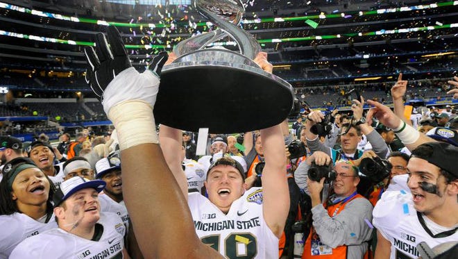 Michigan State Spartans quarterback Connor Cook (18) holds up the Cotton Bowl trophy after the game against the Michigan State Spartans in the 2015 Cotton Bowl Classic at AT&T Stadium. Michigan State beat Baylor 42-41.
