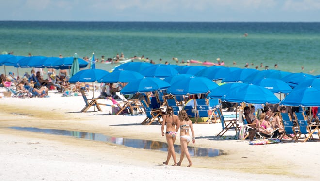 Beachgoers crowd the beach of Seaside in Walton County, Florida on Wednesday, July 19, 2017.