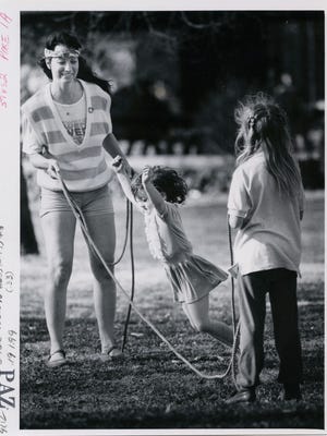 Annika Comstock and her daughters, Anna (center), 4, and Lotten, 8, enjoy a sunny afternoon in Phelps Grove Park in March of 1986.