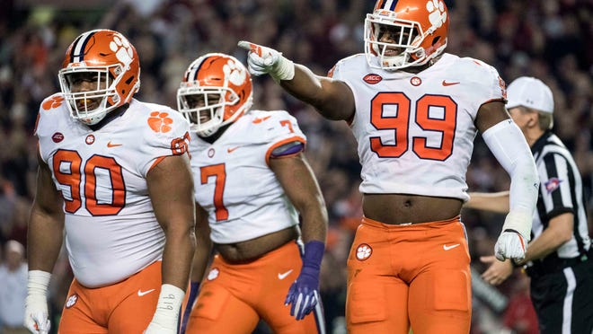FILE - In this Nov. 25, 2017, file photo, Clemson defensive end Clelin Ferrell (99), Dexter Lawrence (90) and Austin Bryant (7) celebrate after a sack in the first half of an NCAA college football game against South Carolina in Columbia, S.C. Defensive tackle Christian Wilkins and defensive ends Clelin Ferrell and Austin Bryant all could have left school after last season and been NFL picks. Instead, they all returned for another season. (AP Photo/Sean Rayford, File)