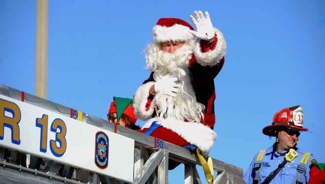 Santa waves to the crowd during last year's Pensacola Beach Surfin' Santa Parade.
