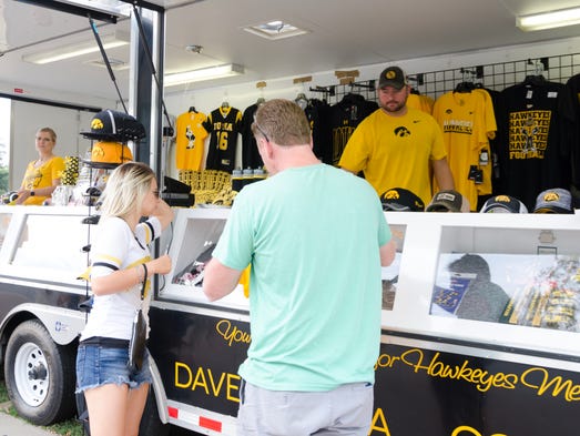 Two people buy Hawkeye merchandise before the Iowa