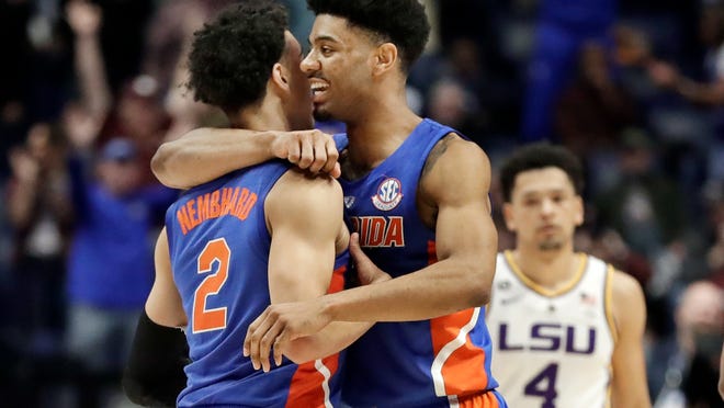 Florida guard Andrew Nembhard (2) is hugged by Jalen Hudson after Nembhard hit the winning 3-point basket against LSU in the second half of an NCAA college basketball game at the Southeastern Conference tournament Friday, March 15, 2019, in Nashville, Tenn. Florida won 76-73. At right is LSU guard Skylar Mays (4). (AP Photo/Mark Humphrey)