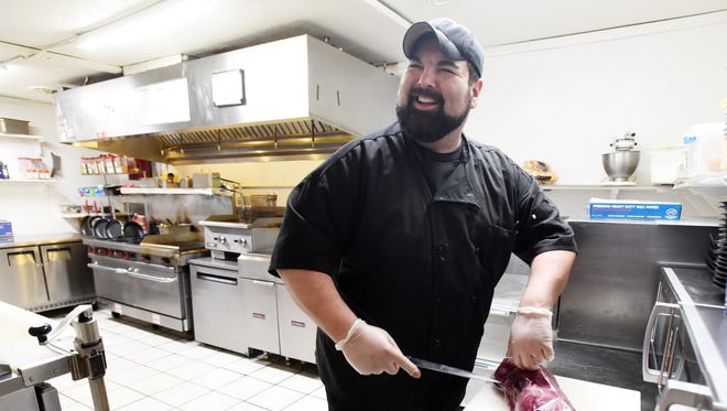 Bob Burdette, owner of The Boondocks in McConnelsville, smiles as he gets ready to cut steaks. The restaurant is celebrating 10 years of business this year.