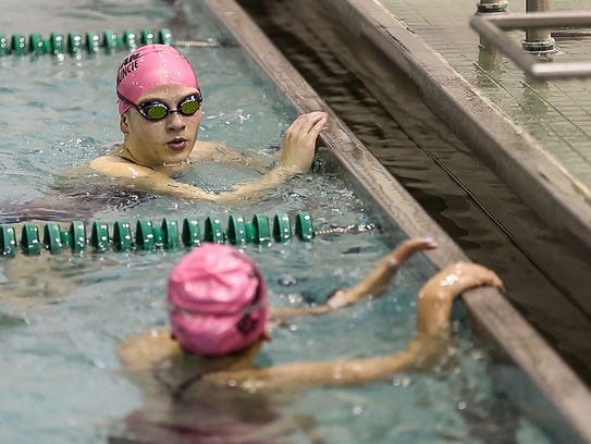 Top, Emily Weiss chats with a teammate between exercises