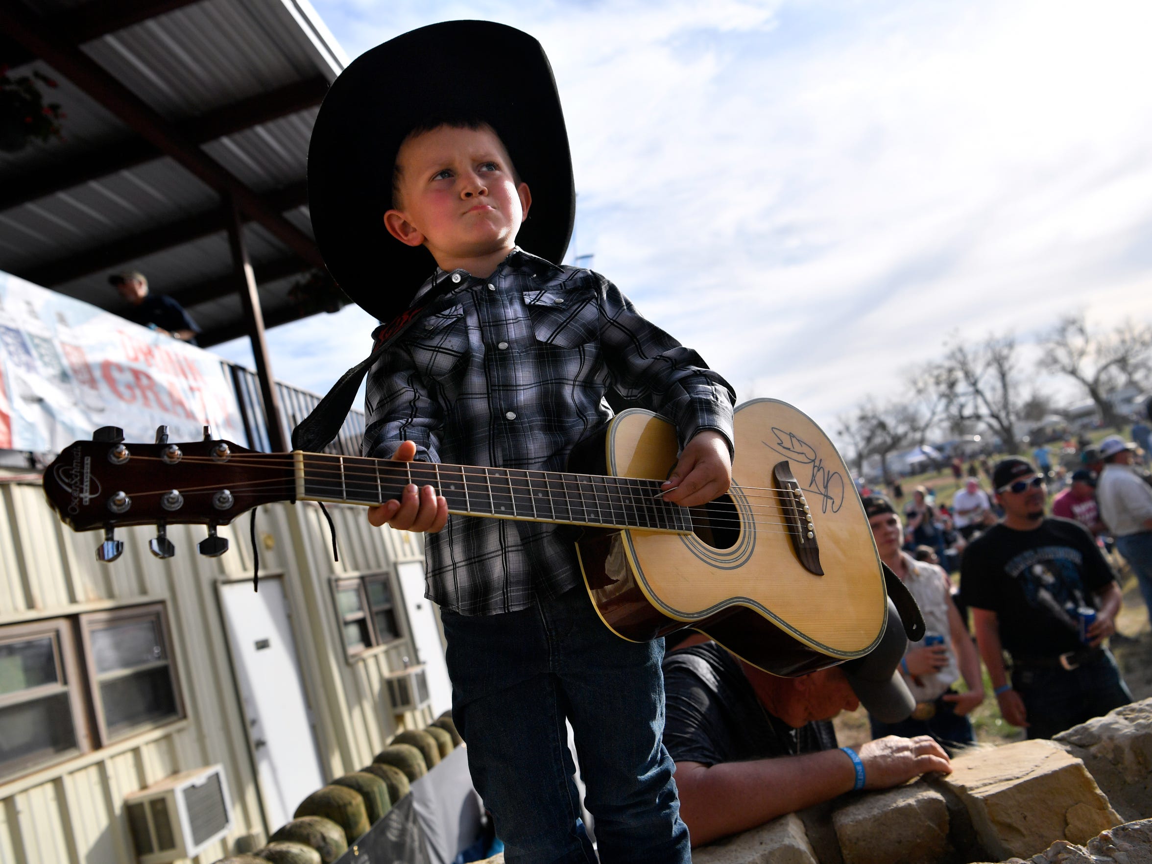 Bubba Crabtree, then 5, "performs" at the side of the stage in 2018. His guitar is autographed by many of the Outlaws & Legends artists.