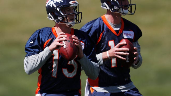 FILE - In this April 27, 2017, file photo, Denver Broncos quarterbacks Trevor Siemian (13) and Paxton Lynch are look to pass during a voluntary minicamp at the team' headquarters in Englewood, Colo. The Broncos, a team with a dazzling defense and ambitions of a deep playoff run, must decide which young quarterback will lead them in 2017: the gifted first rounder Paxton Lynch or the egghead seventh rounder Trevor Siemian. (AP Photo/David Zalubowski, File)