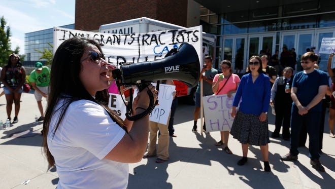 Drake student Kenia Ornelas of Des Moines, a DREAMer and undocumented immigrant, leads a group of protesters in a chant Friday, Aug. 5, 2016, outside of a rally for Republican presidential nominee Donald Trump at Hy-Vee Hall in downtown Des Moines.