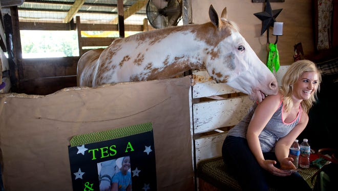 Tristin Pilat, of Casco Township, reacts as her sister's horse, Dexter, licks her arm while resting in a barn during the St. Clair County 4-H and Youth Fair Tuesday, July 21, 2015 at Goodells County Park.