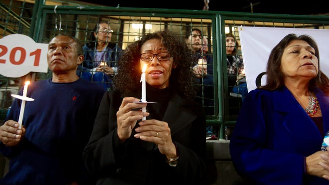 Xeneida Brown, center, and her husband Federico Smith of Rancho Cucamunga, attend the Vigil on Thursday. Rachel Flores of San Bernardino also pictured.