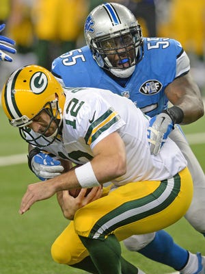 Green Bay Packers quarterback Aaron Rodgers (12) gets sacked by linebacker Stephen Tulloch (55) against the Detroit Lions at Ford Field in Detroit.