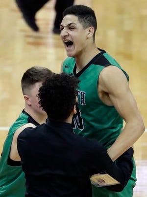 Oshkosh North's Quincy Anderson celebrates with teammates after their 57-56 victory over Sussex Hamilton on Friday in a WIAA Division 1 boys state basketball quarterfinal at the Kohl Center in Madison.