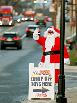 On-air personality Bobby D, of the 96.1 FM  WSOX Wake Up Crew, waves at passing cars during the first day of the second annual Toys for Tots Santa D fundraiser on the Columbia-Wrightsville Bridge on Route 462 in Columbia, Monday, Dec. 12, 2016. This year's goal is to gather 5,000 toys in five days. Dawn J. Sagert photo