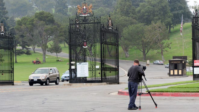 A TV cameraman films the scene as vehicles exit the Forest Lawn Memorial Park, the final resting place of Michael Jackson, in Glendale, Calif., on June 25, 2014, the fifth anniversary of his death.