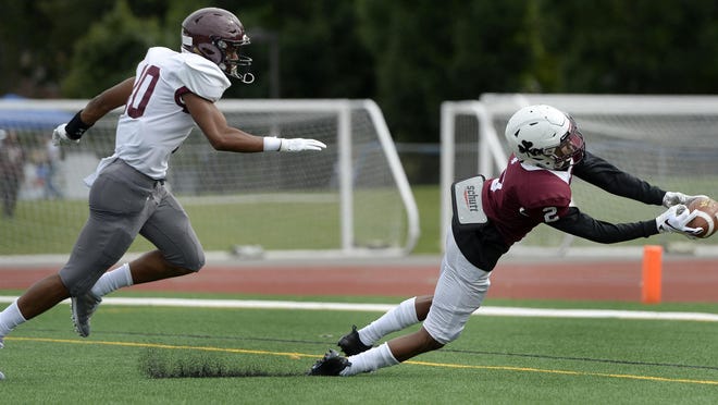 Aquinas’ Kobe McNair, right, makes a diving touchdown catch during a Saturday, Sept. 22, 2018 game. McNair did everything he could Saturday against Friendship Collegiate.