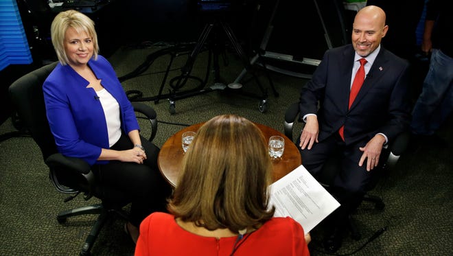 Candidates in New Jersey's contentious and close 3rd Congressional District, Democrat Aimee Belgard, left, and Republican Tom MacArthur, right, appear together to answer questions in joint interview on NJTV with host Marie DeNoia Aronsohn, center, in Trenton, N.J. on Friday, Sept. 26, 2014. (AP Photo/Mel Evans)