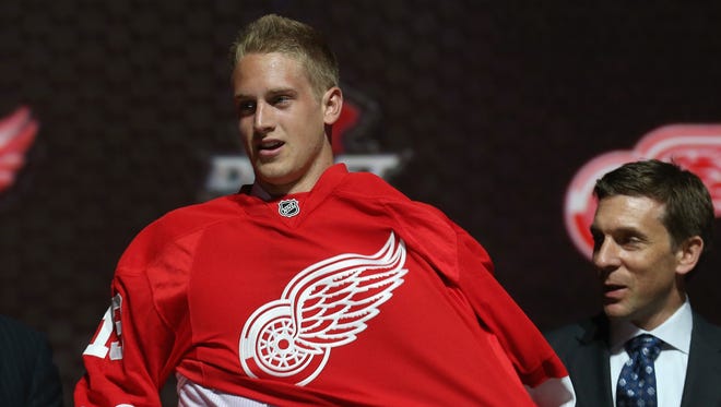 Anthony Mantha puts on his jersey after being selected by the Detroit Red Wings during the 2013 NHL draft.