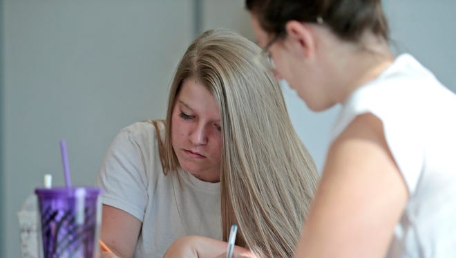 GED student Faith Rowland, 17, of Boone County, completes a worksheet with help from her teacher Erin McGlone during a math lesson at the Gateway Community & Technical College in Florence.
