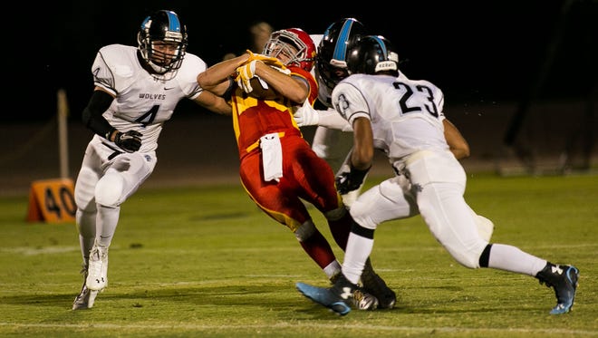 Seton Catholic's George Wolter is tackled by Estrella Foothills defenders on Aug. 29, 2014.
