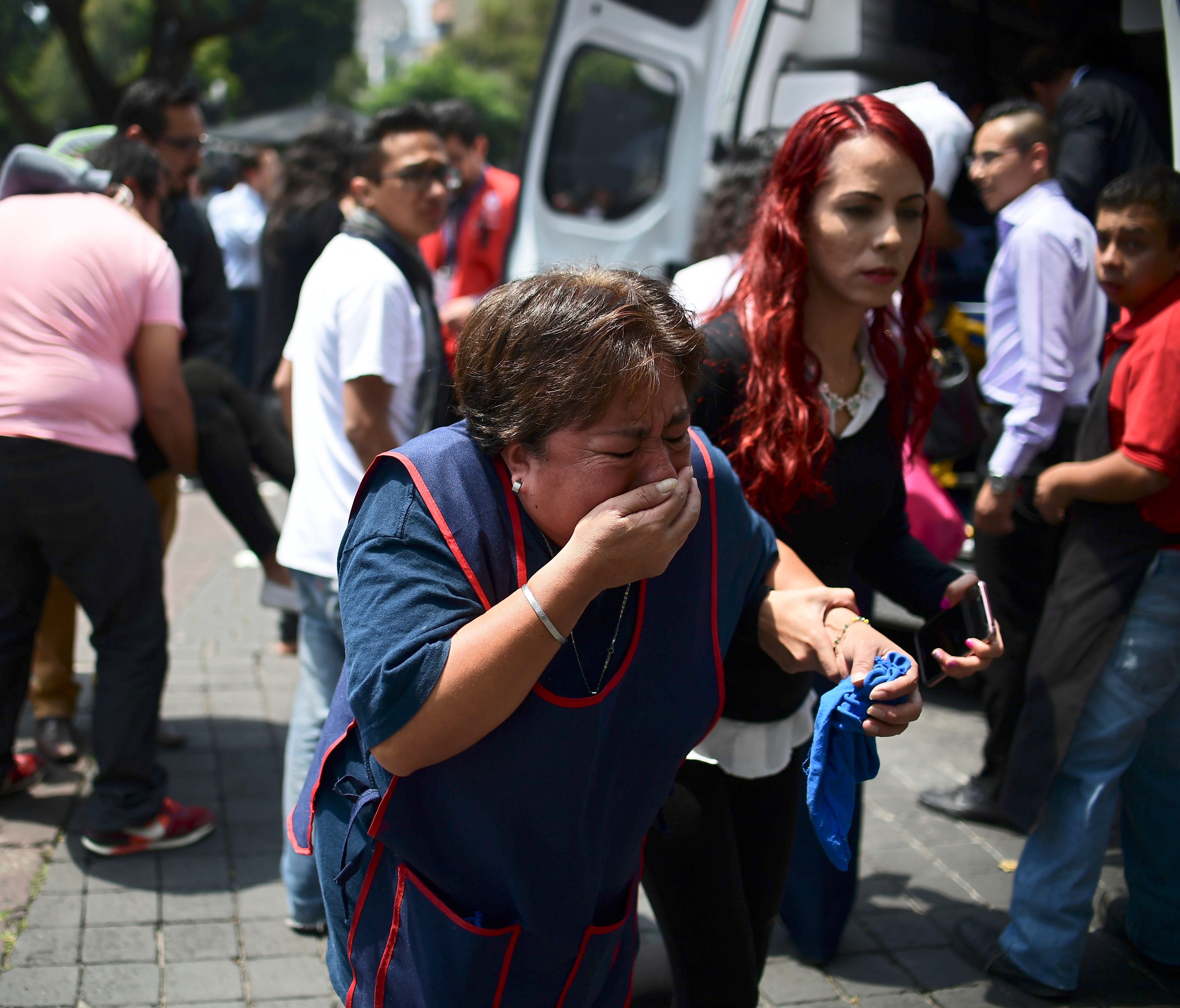 People react after a real quake rattled Mexico City on Sept. 19, 2017 moments after an earthquake drill was held in the capital.