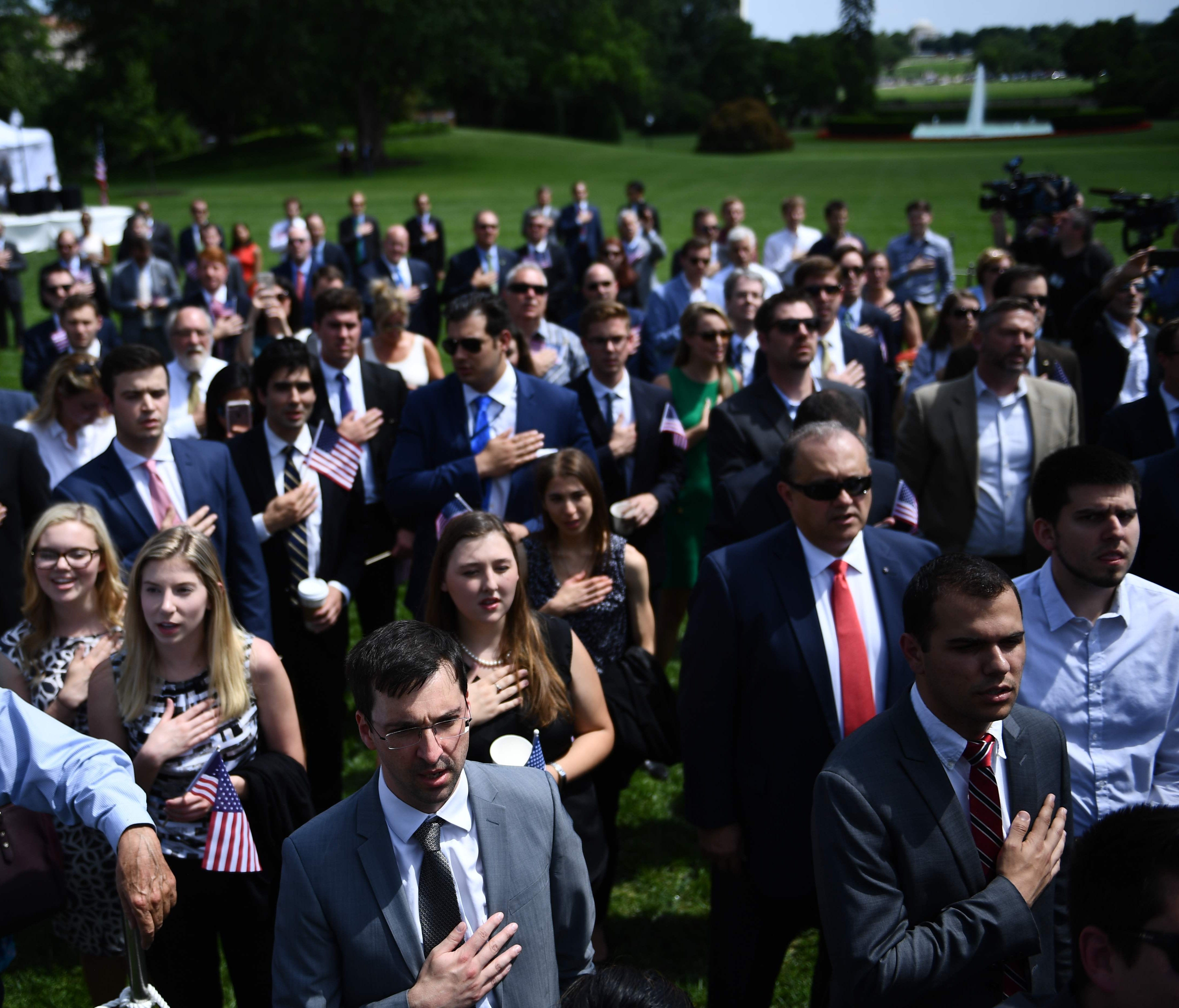 Attendees sing the US National Anthem in the 