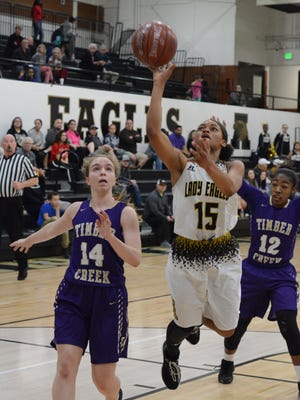Abilene High's Triniti Wilson shoots a floater in the lane in front of Keller Timber Creek's Kristen Gould (14) and Lanae Johnson-Kleinpeter (12) during the Lady Eagles' 49-36 loss Tuesday at Eagle Gym.