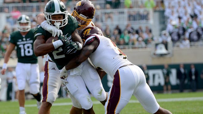 Michigan State running back Gerald Holmes (24) fights for extra yardage in the fourth quarter of the Spartans 30-10 win over the Chippewas at Spartan Stadium, Saturday, September 26, 2015. Holmes finished with 22 yards rushing and two touchdowns.