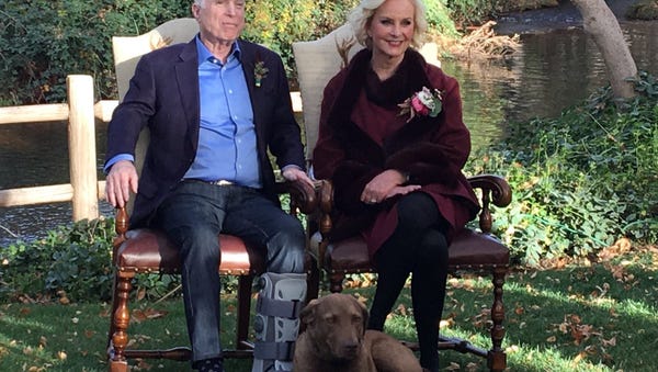 John and Cindy McCain pose with their dog,...