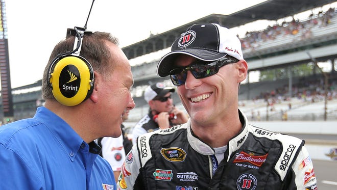 NASCAR driver Kevin Harvick is all smiles as he jokes with Dr. Jerry Punch with ESPN moments after climbing out of his car after winning the pole at the Indianapolis Motor Speedway on Saturday, July 26, 2014. Harvick broke the track qualifying record with a speed of 188.470.