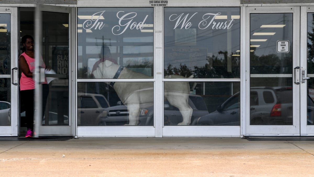 The "In God We Trust" phrase can be seen in the windows of the front doors at Milan High School in Milan, Tenn., on Tuesday, Aug. 14, 2018.