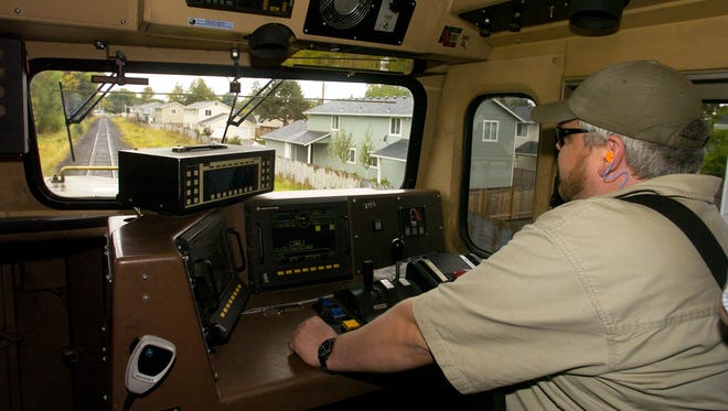 Union Pacific train engineer Grant Goodell drives south near Market Street in 2006. Railroads are adding safety systems to prevent speed accidents.