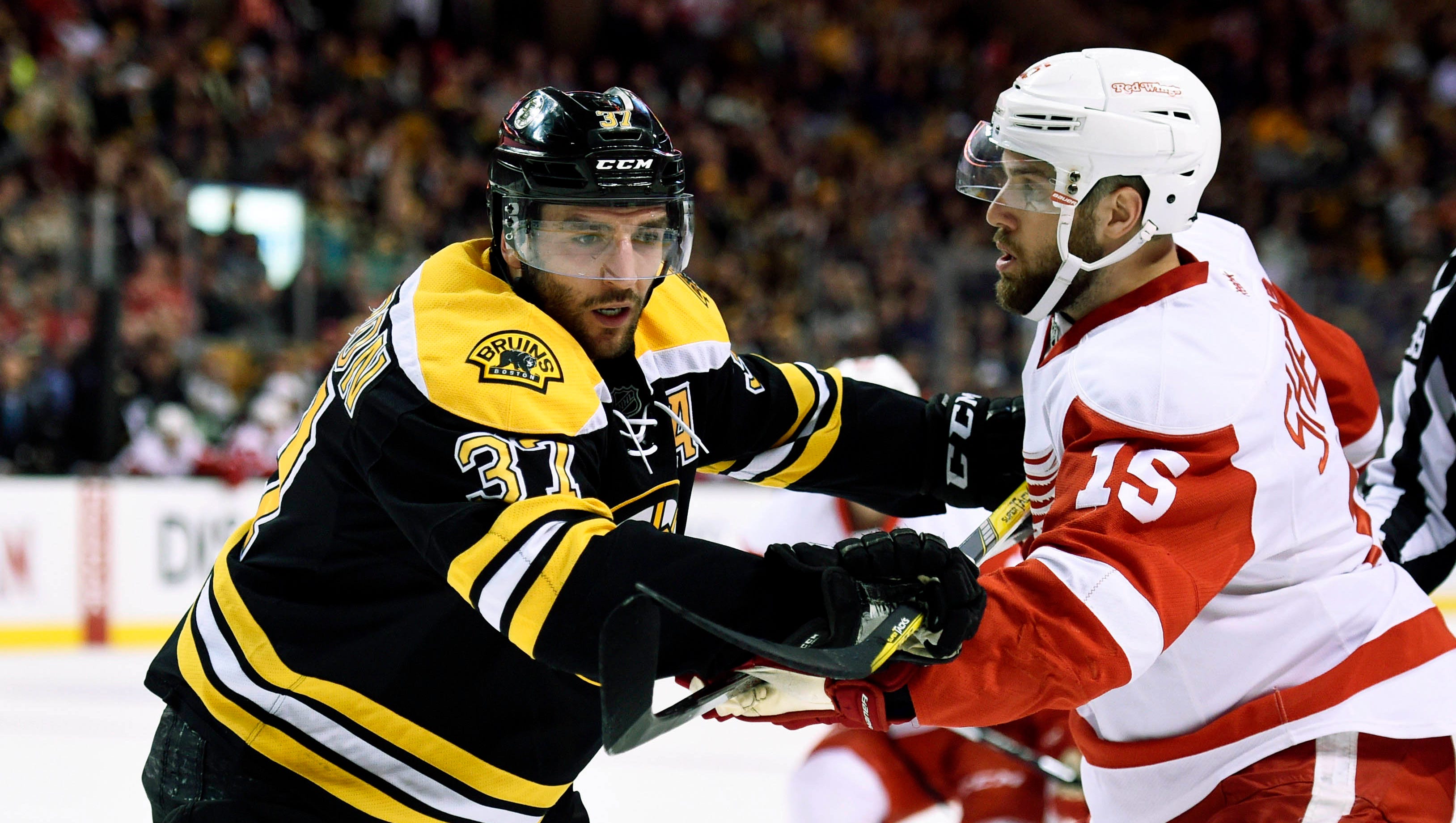 Bruins center Patrice Bergeron (37) battles with Red Wings center Riley Sheahan (15) after a face-off during the first period of the Wings' 5-2 loss Thursday in Boston.